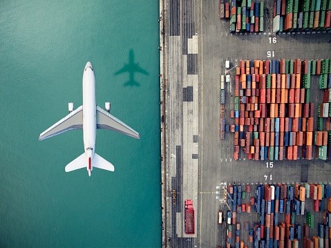 airplane flying over container port picture id636036276