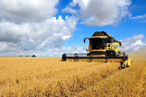 combine harvester and tractor in barley field during harvest picture id166308616